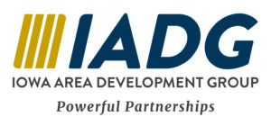 Four gold vertical bars next to ‘IADG’ in navy, with ‘Iowa Area Development Group’ in gray uppercase letters below and the tagline ‘Powerful Partnerships’ beneath.